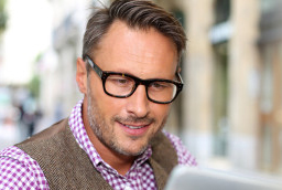 Person with glasses looking at laptop