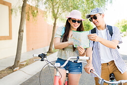 couple reading map on bikes in the city
